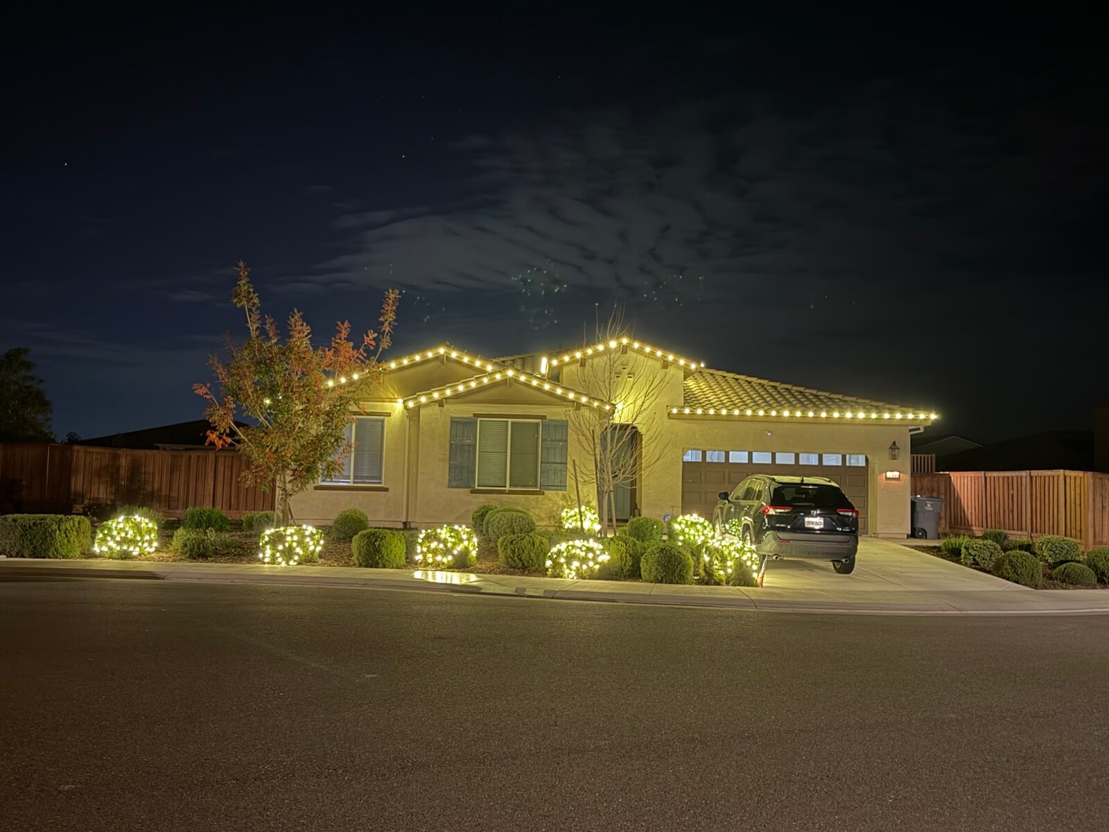 Christmas light installers in El Dorado Hills, CA: single story stucco warm white roofline lit shrubs